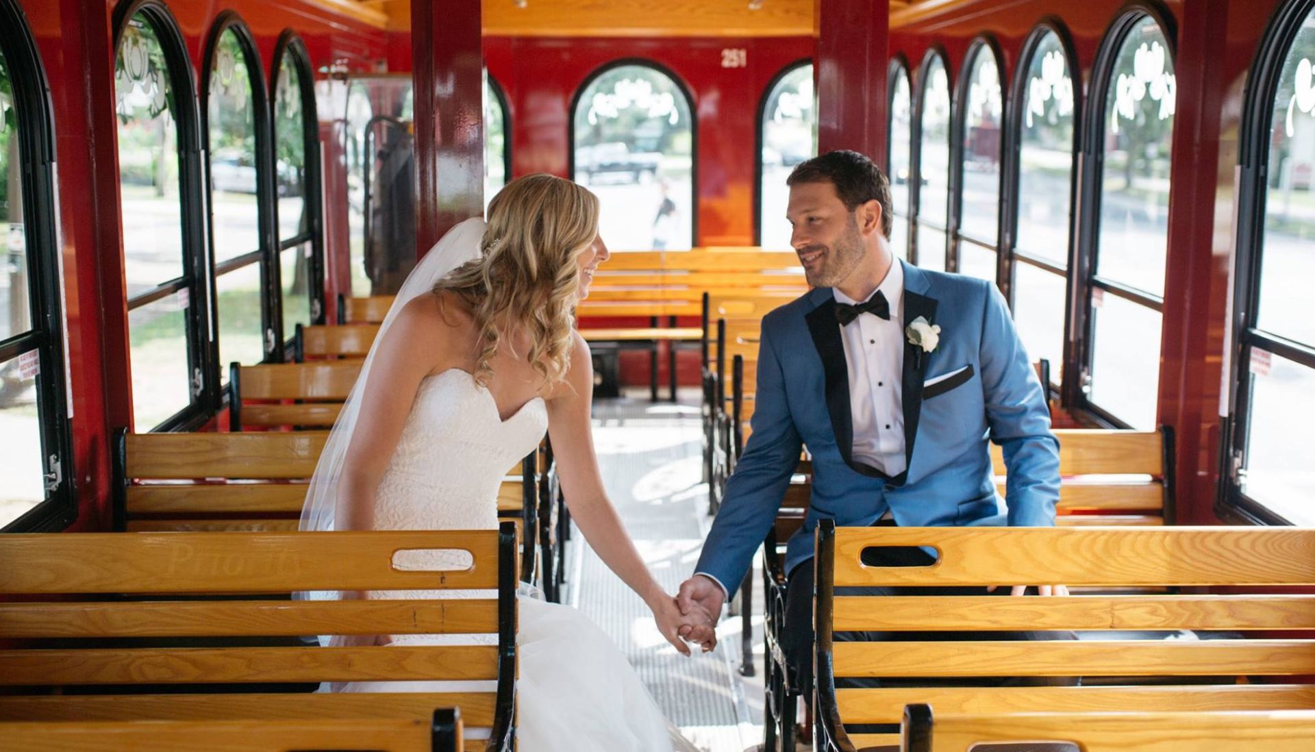 bride and groom holding hands on trolley
