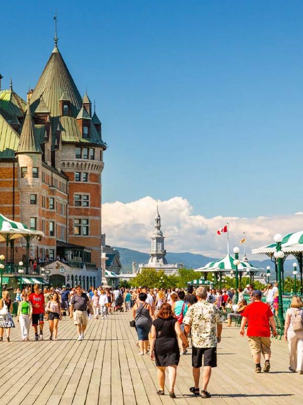 people walking down a sunny boardwalk in Canada