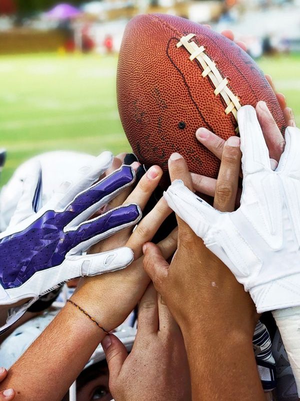 hands raising a football